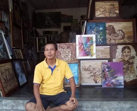 Wawan Susanto bersama karya lukis pelepah pisang miliknya