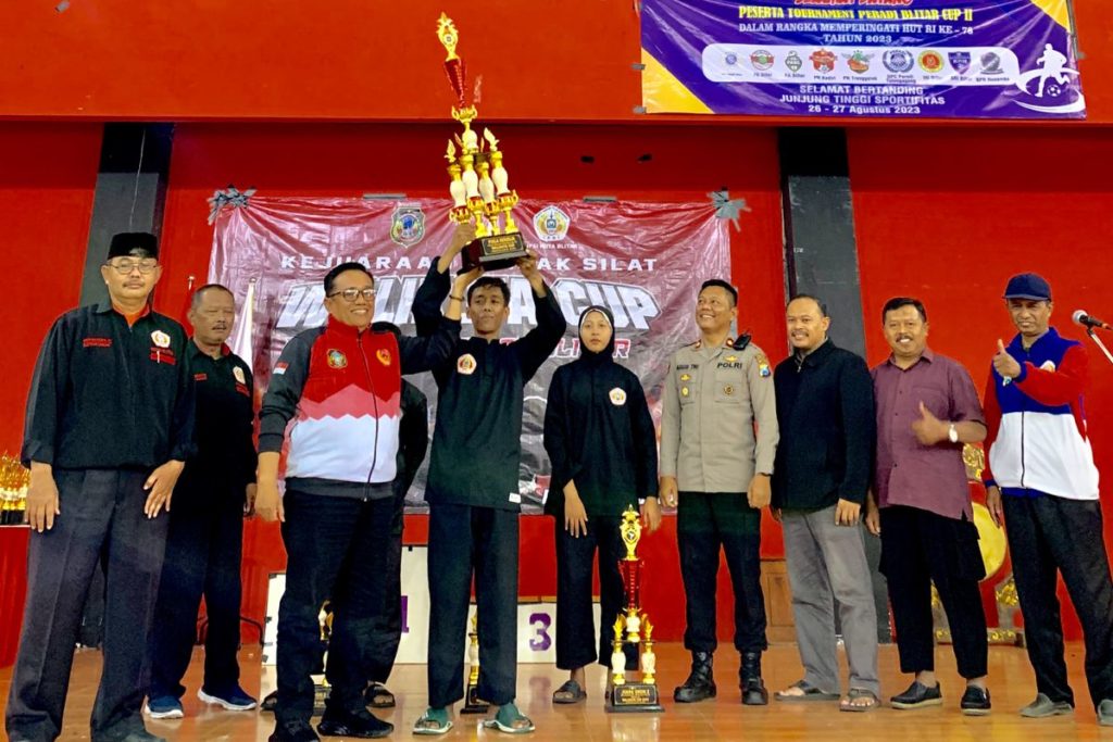 Foto Pelatih Golden Silat Club, Burhanuddin Abdullah saat mengangkat trophy piala umum di Pertandingan Pencak Silat Walikota Cup 2023 (Doc. Istimewa)