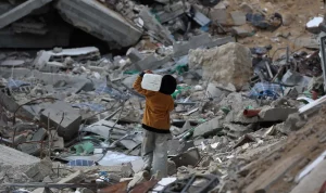 Saat ini jutaan anak masih menghadapi masalah-masalah yang sering membuat mereka merasa terancam hingga menimbulkan rasa takut. Tampak dalam foto, seorang anak laki-laki Palestina membawa sebuah wadah plastik saat dia berjalan melewati puing-puing di samping sebuah bangunan yang hancur akibat pemboman Israel baru-baru ini di Khan Yunis di Jalur Gaza selatan pada 19 November 2024.